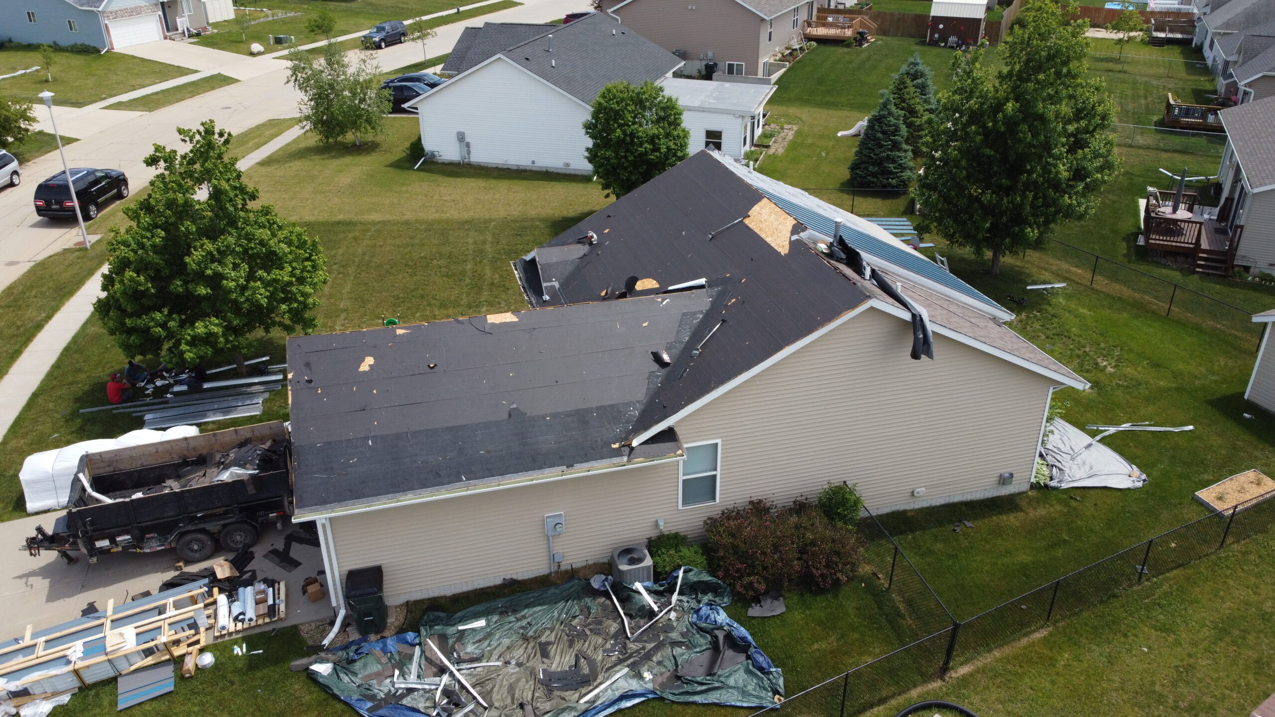 Aerial view of an old roof being torn off by the experienced Trego Custom Homes crew"