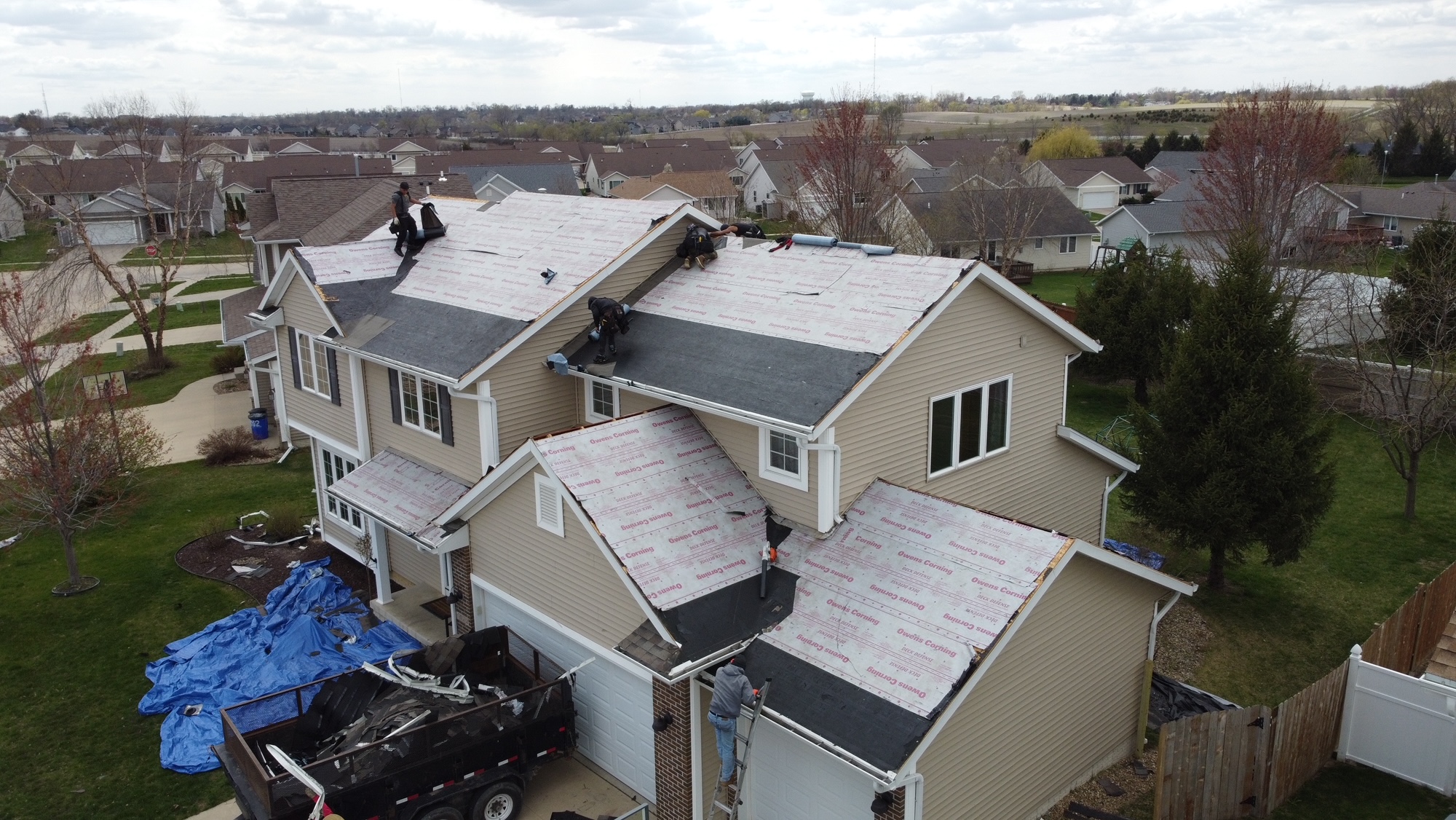 Multi-story home with old roof removed by Trego Custom Homes crew for replacement