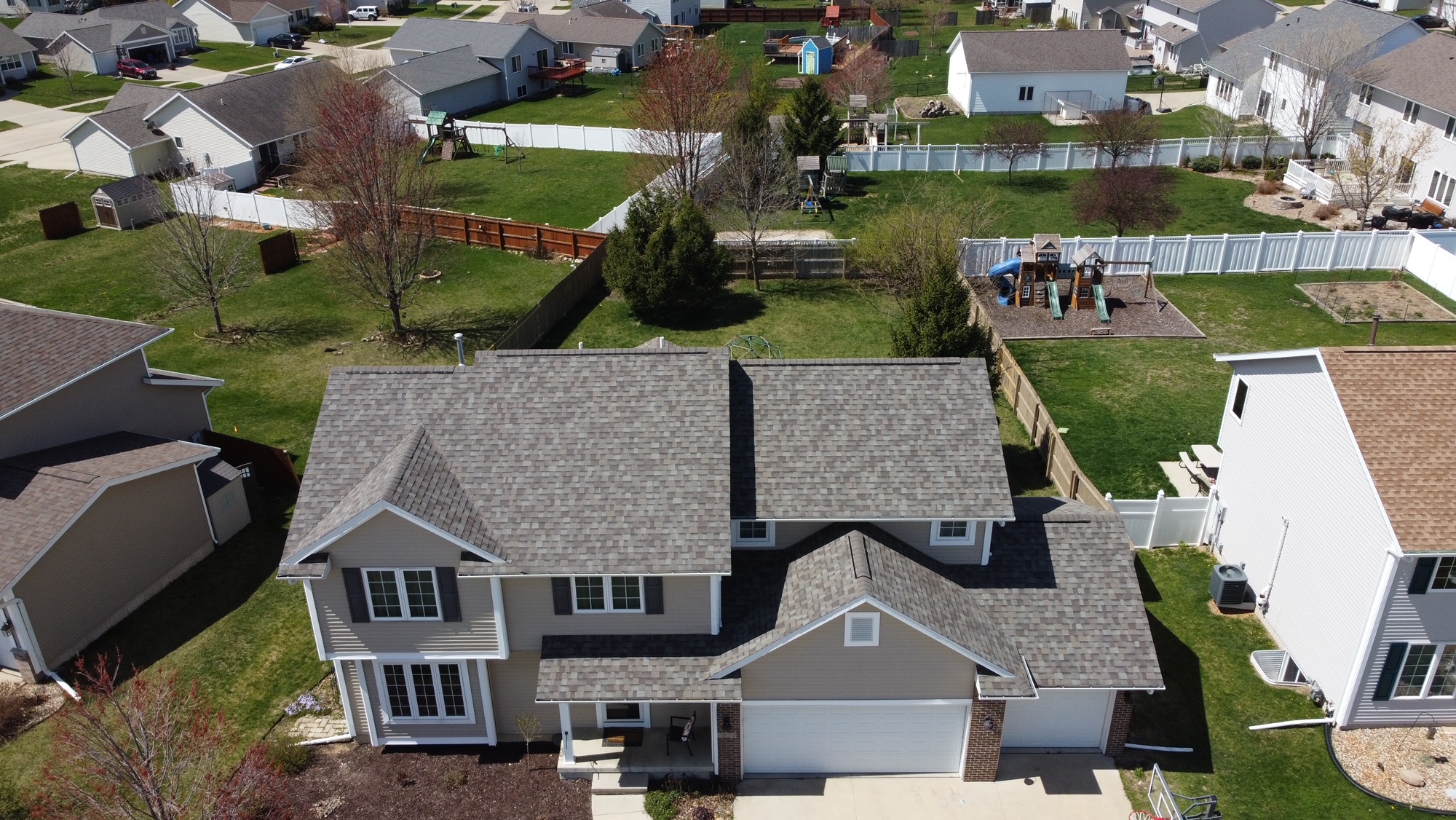 Aerial view of a completed custom roof on a multi-story home by Trego Custom Homes